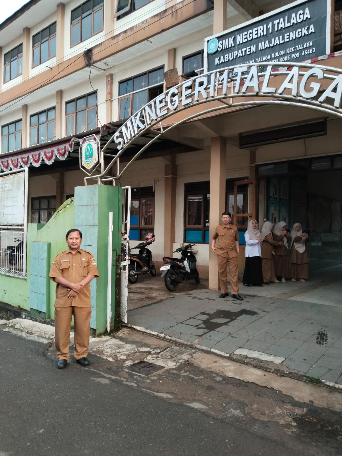 Kepala Sekolah Menyambut Pagi di Gerbang Sekolah